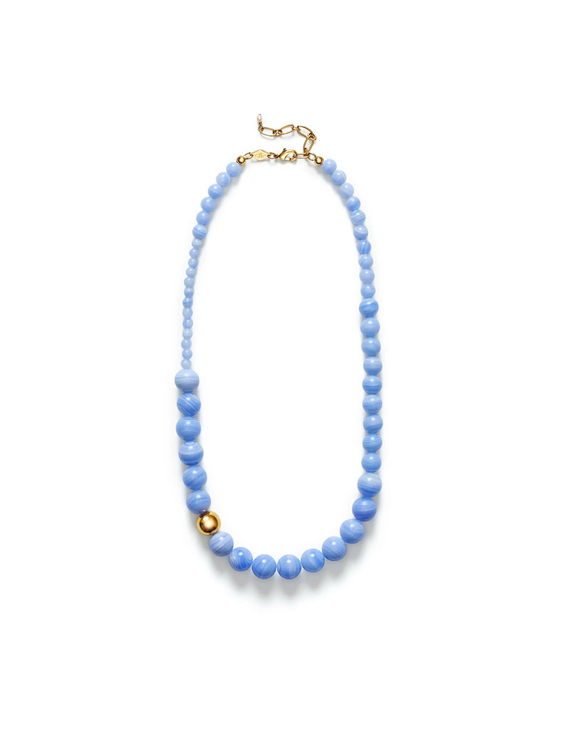 Naszyjnik Float ANNI LU z dużych, okrągłych paciorków z błękitnego agatu. Wykończony cienkim łańcuszkiem o regulowanej długości z niewielką, naturalną perłą na jego końcówce.&nbsp;