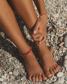 Gruba bransoletka na kostkę Reef Anklet ANNI LU z nieregularnej wielkości kamieni z bambusa morskiego przeplatanymi z małymi, szklanymi koralikami. Wykończony pozłacanym łańcuszkiem o regulowanej długości zakończonym malutką perłą słodkowodną.&nbsp;