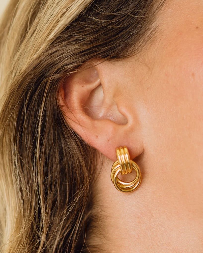 Pozłacane kolczyki Triplet ANNI LU w stylu lat 90. o formie połączonych, potrójnych okręgów. Zapinane na sztyft. 