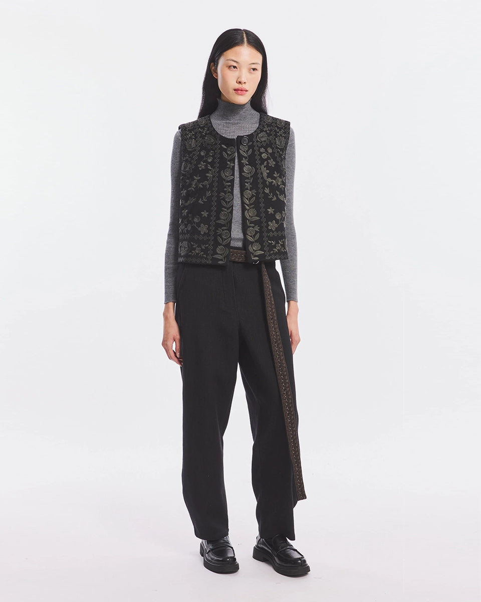 Krótka kamizelka Bertille Black marki Antik Batik o wyraźnym, etnicznym charakterze nawiązującym do stylu boho-chic. Jest to fason sięgający do linii bioder, z otwartym przodem. Zapinana przy szyi za pomocą jednego guzika. Wykonana z miękkiej tkaniny z wełną. Kamizelka ma podszewkę.