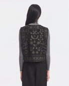 Krótka kamizelka Bertille Black marki Antik Batik o wyraźnym, etnicznym charakterze nawiązującym do stylu boho-chic. Jest to fason sięgający do linii bioder, z otwartym przodem. Zapinana przy szyi za pomocą jednego guzika. Wykonana z miękkiej tkaniny z wełną. Kamizelka ma podszewkę.