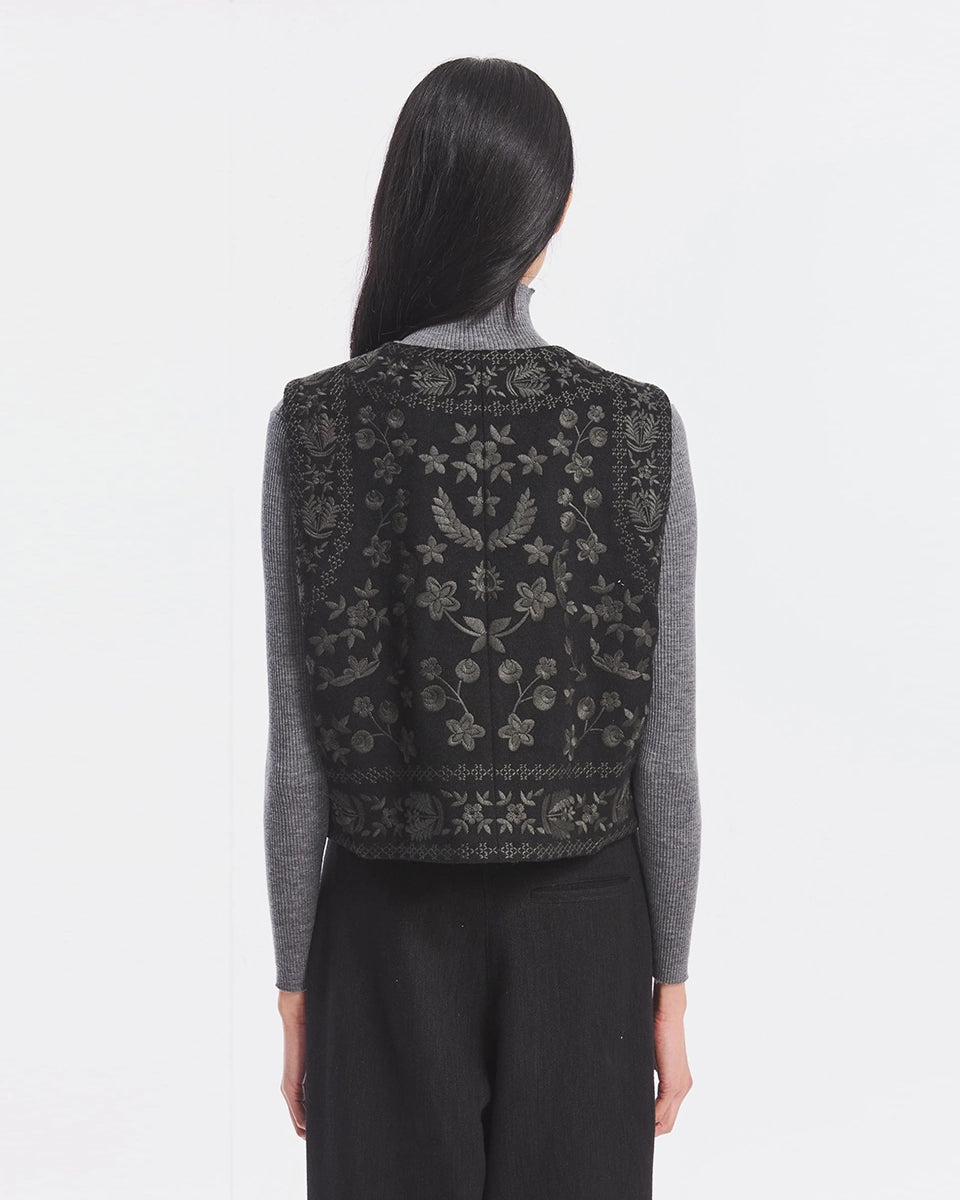 Krótka kamizelka Bertille Black marki Antik Batik o wyraźnym, etnicznym charakterze nawiązującym do stylu boho-chic. Jest to fason sięgający do linii bioder, z otwartym przodem. Zapinana przy szyi za pomocą jednego guzika. Wykonana z miękkiej tkaniny z wełną. Kamizelka ma podszewkę.