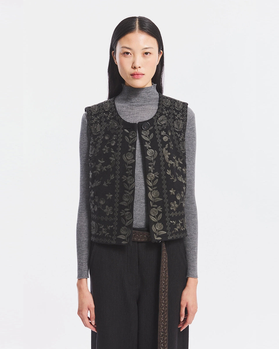 Krótka kamizelka Bertille Black marki Antik Batik o wyraźnym, etnicznym charakterze nawiązującym do stylu boho-chic. Jest to fason sięgający do linii bioder, z otwartym przodem. Zapinana przy szyi za pomocą jednego guzika. Wykonana z miękkiej tkaniny z wełną. Kamizelka ma podszewkę.