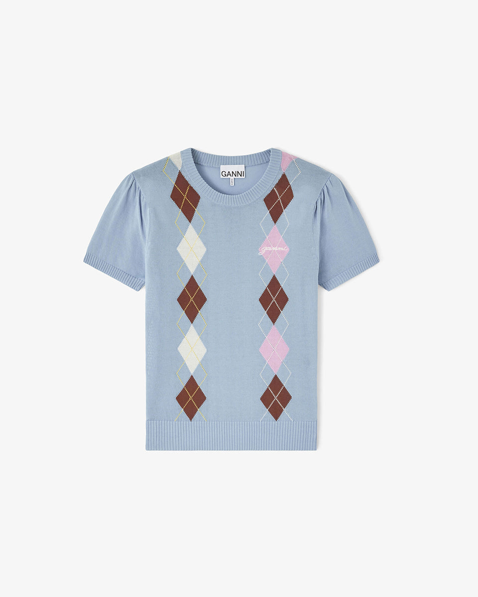 Dzianinowy, jasnoniebieski T-shirt Argyle GANNI Soft Chambray z krótkimi rękawami z marszczeniami i okrągłym dekoltem. Charakteryzuje go klasyczny wzór ułożony w dwa pionowe pasy z przodu, które łączą odcienie brązu, beżu i pastelowego różu. Wykończona ściągaczami. Całość uzupełnia dyskretny haft z logo marki. Wykonany z bawełny.

-Marszczone rękawki

-Okrągły dekolt

-Wykończony ściągaczami