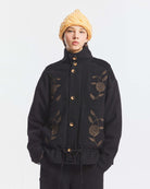 Kurtka o kroju oversize Aristide Antik Batik Grey z wysokim kołnierzem i zapięciem na guziki. Wykonana z mieszanki bawełny, wełny i nylonu. Model ten wyróżnia się strukturalną formą i swobodnym ułożeniem na sylwetce. Przód zdobią delikatne, kwiatowe hafty, które nadają kurtce fakturę i charakter. Posiada dwie naszywane kieszenie i dwie kieszenie boczne. Regulowany u dołu sznurek pozwala na dowolne podkreślenie sylwetki. Model wykończony podszewką z lyocellu.&nbsp;