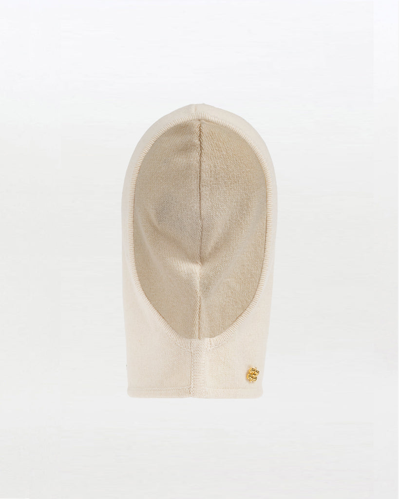Luźna, kremowa balaclava 7205 GANNI Egret z bardzo miękkiej dzianiny z wełny. Posiada niewielką, metalową aplikację z logo marki.