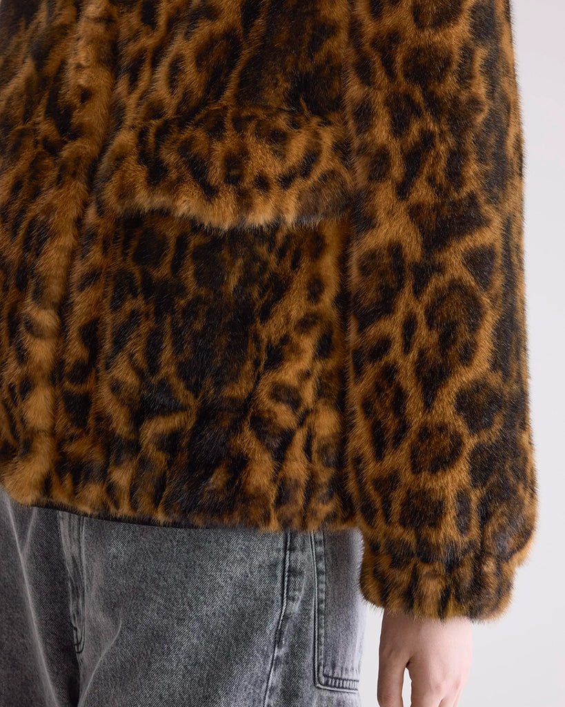 Krótka, kremowa, luźna kurtka ze sztucznego futra Enora Bellerose z wysokim, zapinanym pod szyję kołnierzem i luźnymi, reglanowymi rękawami zakończonymi elastycznymi ściągaczami.