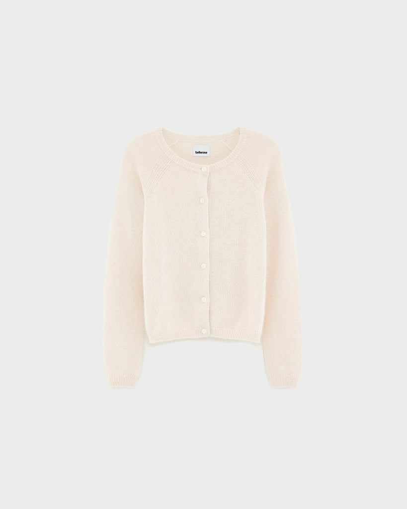Prosty, krótki, kremowy kardigan Datair Bellerose z okrągłym dekoltem. Wykończony ściągaczami. Zapinany na guziki. Sweter ma prosty krój i wykonany jest z bardzo miękkiej i puchatej dzianiny z angorą