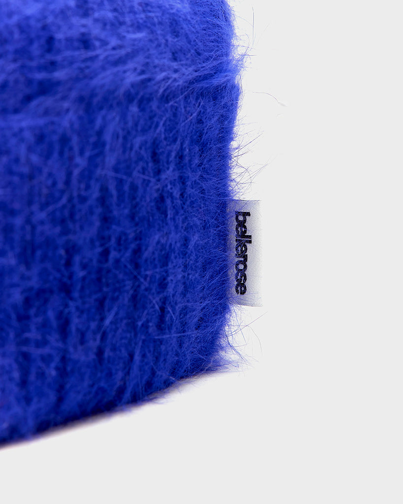 Klasyczna, kobaltowa, wywijana czapka z angorą beanie Datiz Bellerose z prążkowaną fakturą. Posiada niewielką metkę z logo marki.