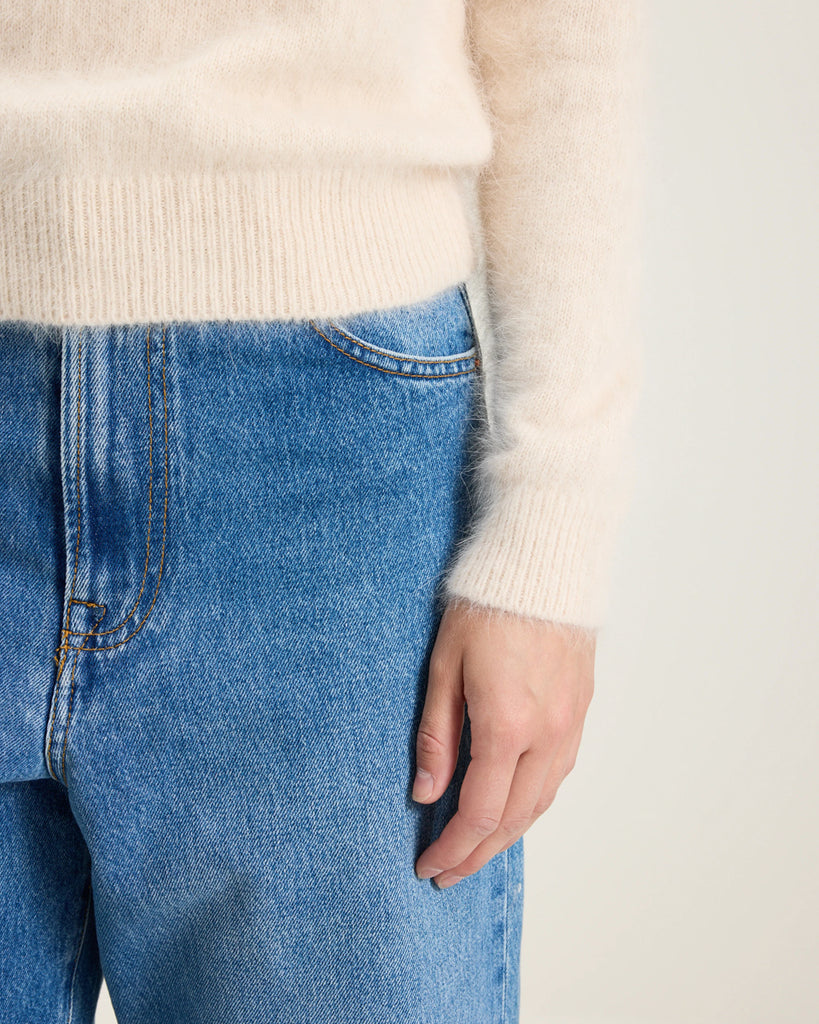 Prosty, krótki, fioletowy sweter Datti Bellerose z okrągłym dekoltem. Wykończony ściągaczami. Sweter wykonany jest z bardzo miękkiej i puchatej dzianiny z angorą.