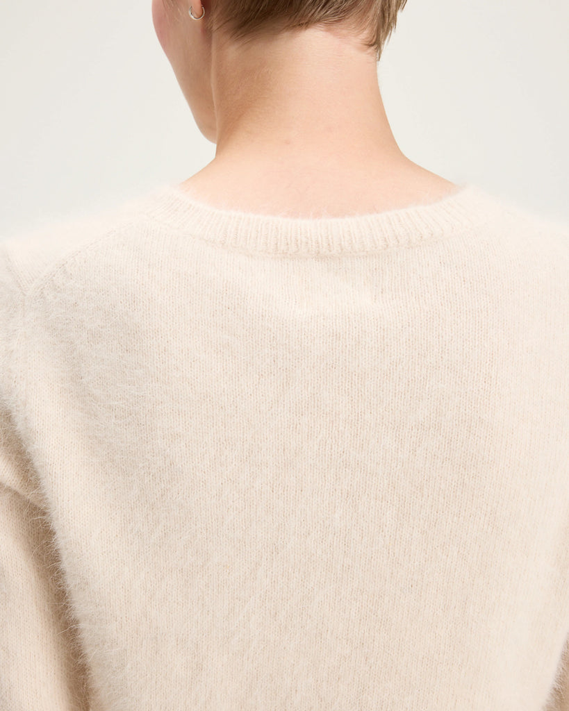 Prosty, krótki, fioletowy sweter Datti Bellerose z okrągłym dekoltem. Wykończony ściągaczami. Sweter wykonany jest z bardzo miękkiej i puchatej dzianiny z angorą.