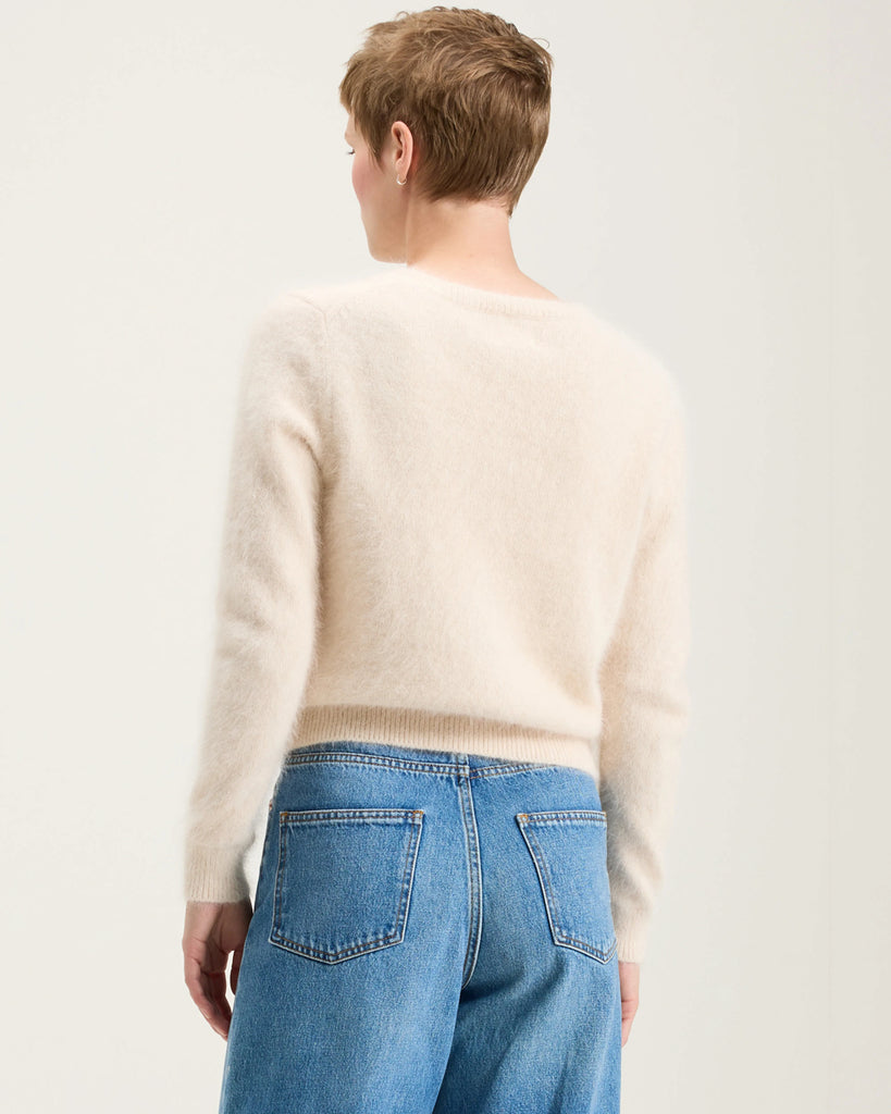 Prosty, krótki, fioletowy sweter Datti Bellerose z okrągłym dekoltem. Wykończony ściągaczami. Sweter wykonany jest z bardzo miękkiej i puchatej dzianiny z angorą.