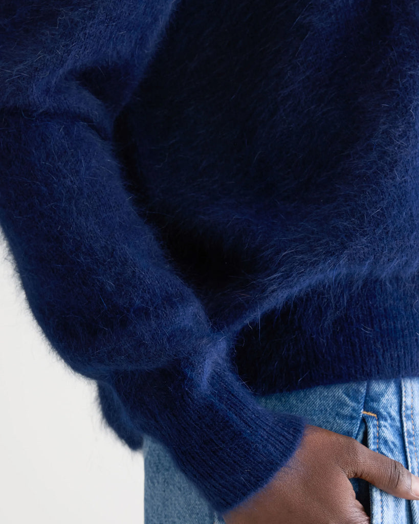 Klasyczny, granatowy, pudełkowy sweter Datus Bellerose z okrągłym dekoltem i opadającymi ramionami. Wykończony ściągaczami. Wykonany z bardzo miłej w dotyku i puchatej dzianiny z angorą.