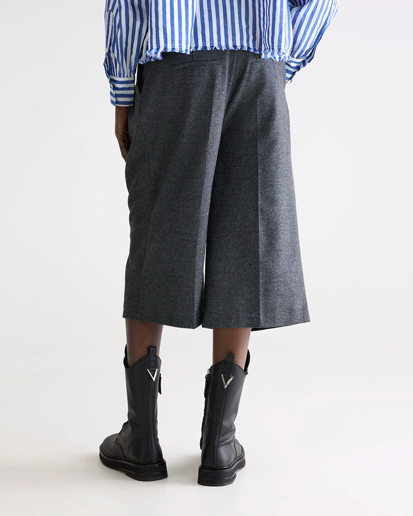 Garniturowe bermudy Dom Bellerose z wysokim stanem i zakładkami. Szorty mają szeroką, prostą nogawkę, dwie boczne i dwie tylne kieszenie. Spodnie mają długość za kolana. 