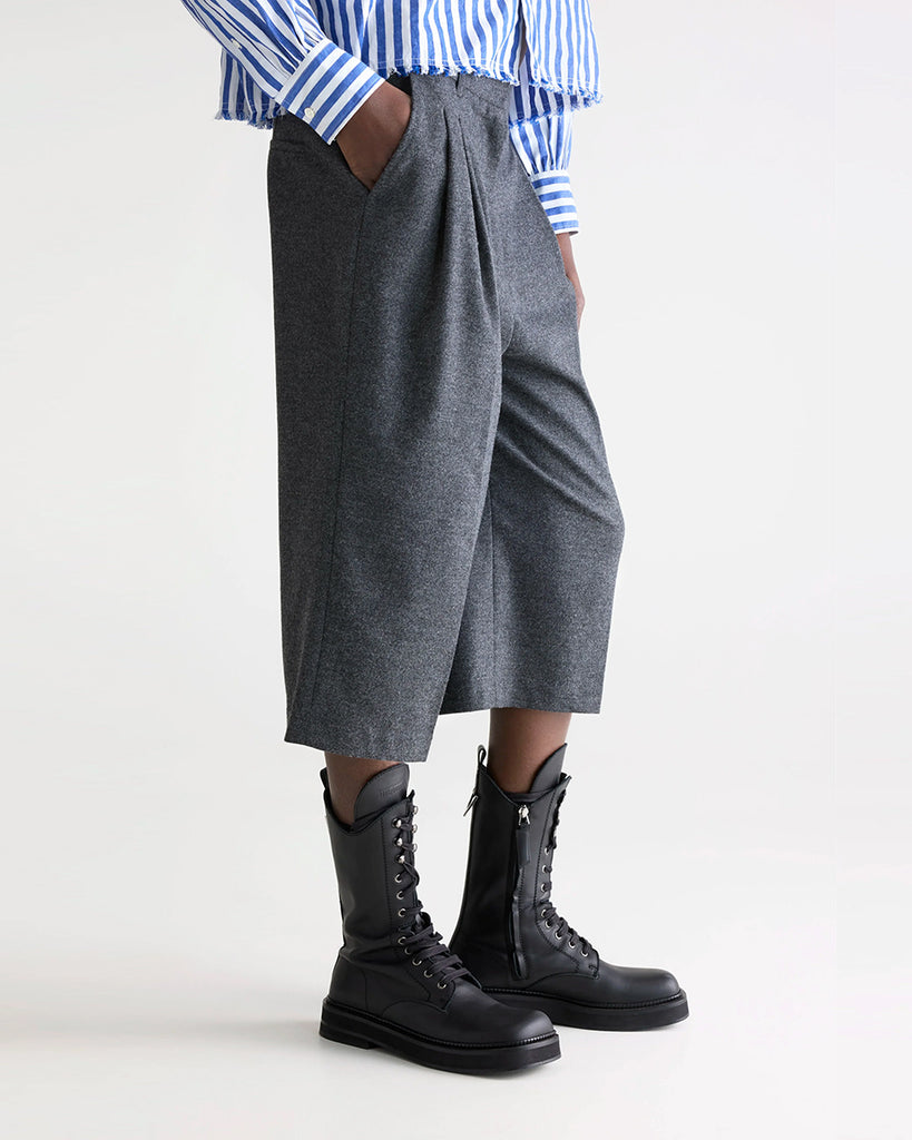 Garniturowe bermudy Dom Bellerose z wysokim stanem i zakładkami. Szorty mają szeroką, prostą nogawkę, dwie boczne i dwie tylne kieszenie. Spodnie mają długość za kolana. 