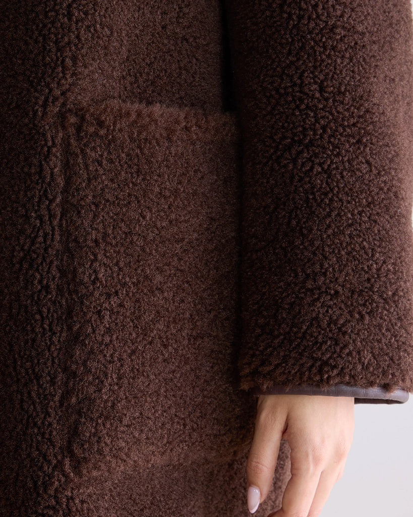 Długi, dwustronny ekologiczny kożuch Easton Bellerose z kołnierzem, opadającymi ramionami i wywijanymi rękawami. Z przodu posiada dwie, duże kieszenie. Zapinany na guziki. Z jednej strony wykonany z gładkiej imitacji skóry, z drugiej ze sztucznego, miłego w dotyku "misia".