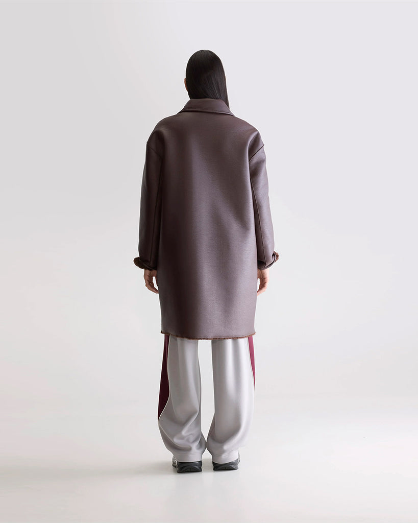 Długi, dwustronny ekologiczny kożuch Easton Bellerose z kołnierzem, opadającymi ramionami i wywijanymi rękawami. Z przodu posiada dwie, duże kieszenie. Zapinany na guziki. Z jednej strony wykonany z gładkiej imitacji skóry, z drugiej ze sztucznego, miłego w dotyku "misia".