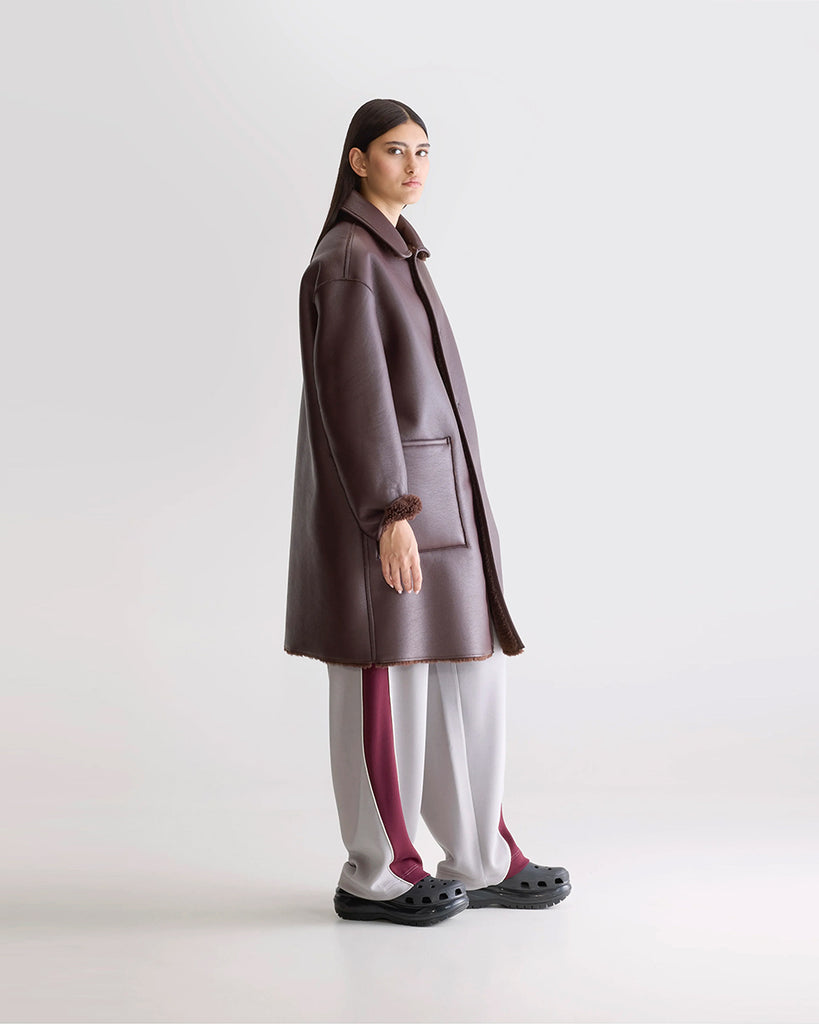 Długi, dwustronny ekologiczny kożuch Easton Bellerose z kołnierzem, opadającymi ramionami i wywijanymi rękawami. Z przodu posiada dwie, duże kieszenie. Zapinany na guziki. Z jednej strony wykonany z gładkiej imitacji skóry, z drugiej ze sztucznego, miłego w dotyku "misia".