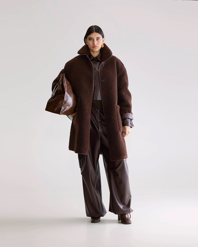 Długi, dwustronny ekologiczny kożuch Easton Bellerose z kołnierzem, opadającymi ramionami i wywijanymi rękawami. Z przodu posiada dwie, duże kieszenie. Zapinany na guziki. Z jednej strony wykonany z gładkiej imitacji skóry, z drugiej ze sztucznego, miłego w dotyku "misia".