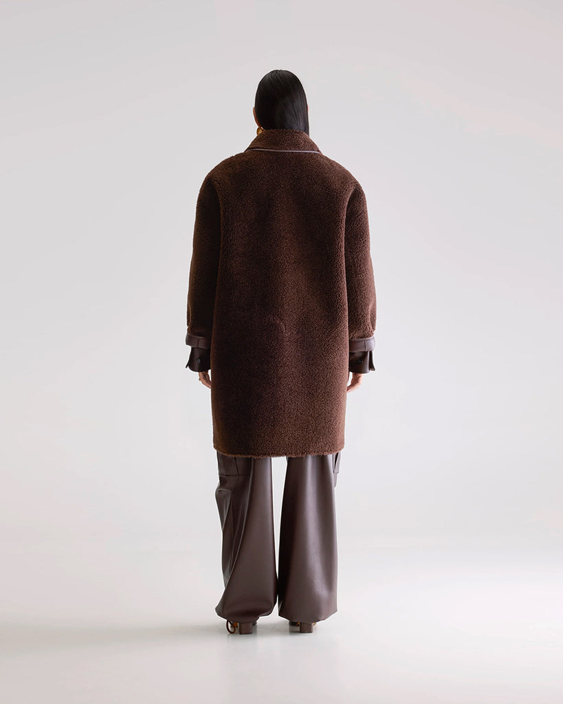 Długi, dwustronny ekologiczny kożuch Easton Bellerose z kołnierzem, opadającymi ramionami i wywijanymi rękawami. Z przodu posiada dwie, duże kieszenie. Zapinany na guziki. Z jednej strony wykonany z gładkiej imitacji skóry, z drugiej ze sztucznego, miłego w dotyku "misia".