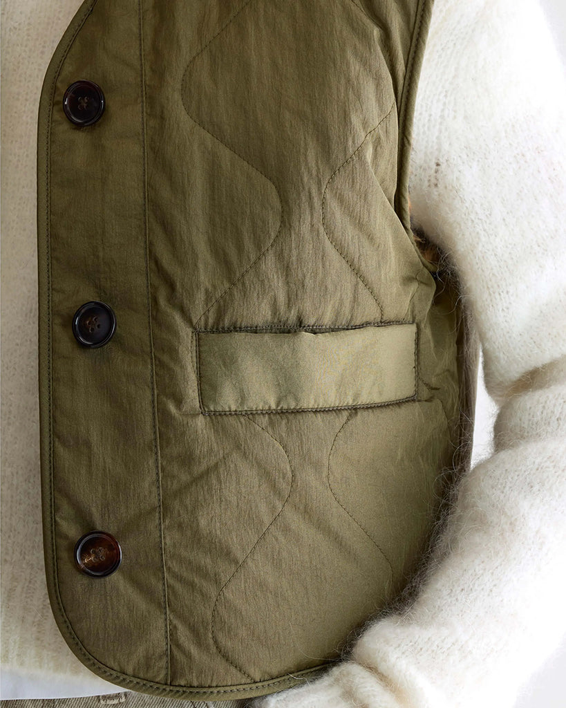 Ciepła, dwustronna kamizelka o pudełkowym fasonie Eloise Bellerose. Z jednej strony wykonana z pikowanej, śliskiej tkaniny w kolorze khaki, z drugiej ze sztucznego, miłego futra w lamparci print.