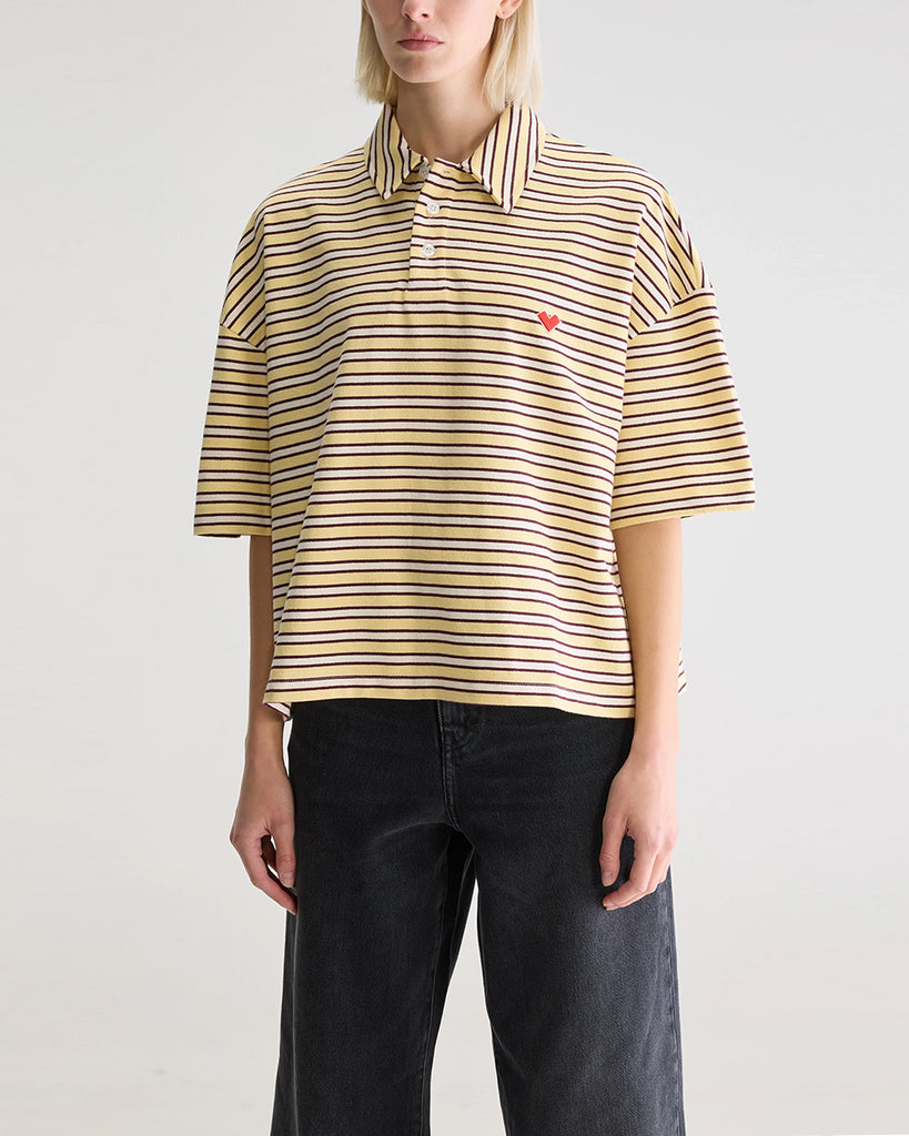 Luźna, pudełkowa koszulka polo Foolo Bellerose w paski. Posiada kołnierzyk, opadające ramiona i krótki, szeroki rękaw o długości do łokci. Pod szyją zapinana na guziki.