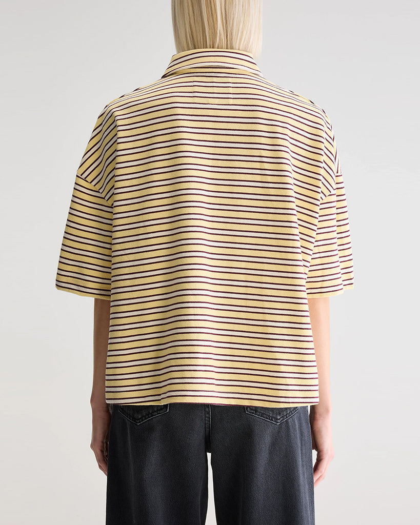 Luźna, pudełkowa koszulka polo Foolo Bellerose w paski. Posiada kołnierzyk, opadające ramiona i krótki, szeroki rękaw o długości do łokci. Pod szyją zapinana na guziki.