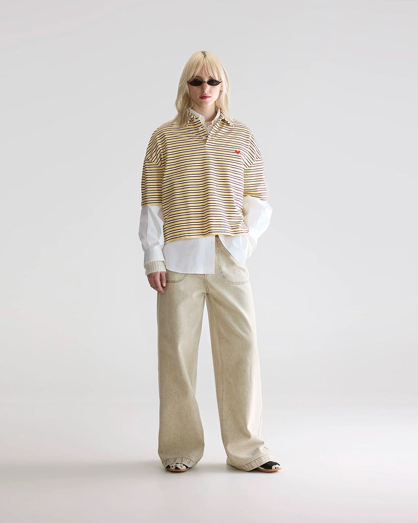 Luźna, pudełkowa koszulka polo Foolo Bellerose w paski. Posiada kołnierzyk, opadające ramiona i krótki, szeroki rękaw o długości do łokci. Pod szyją zapinana na guziki.