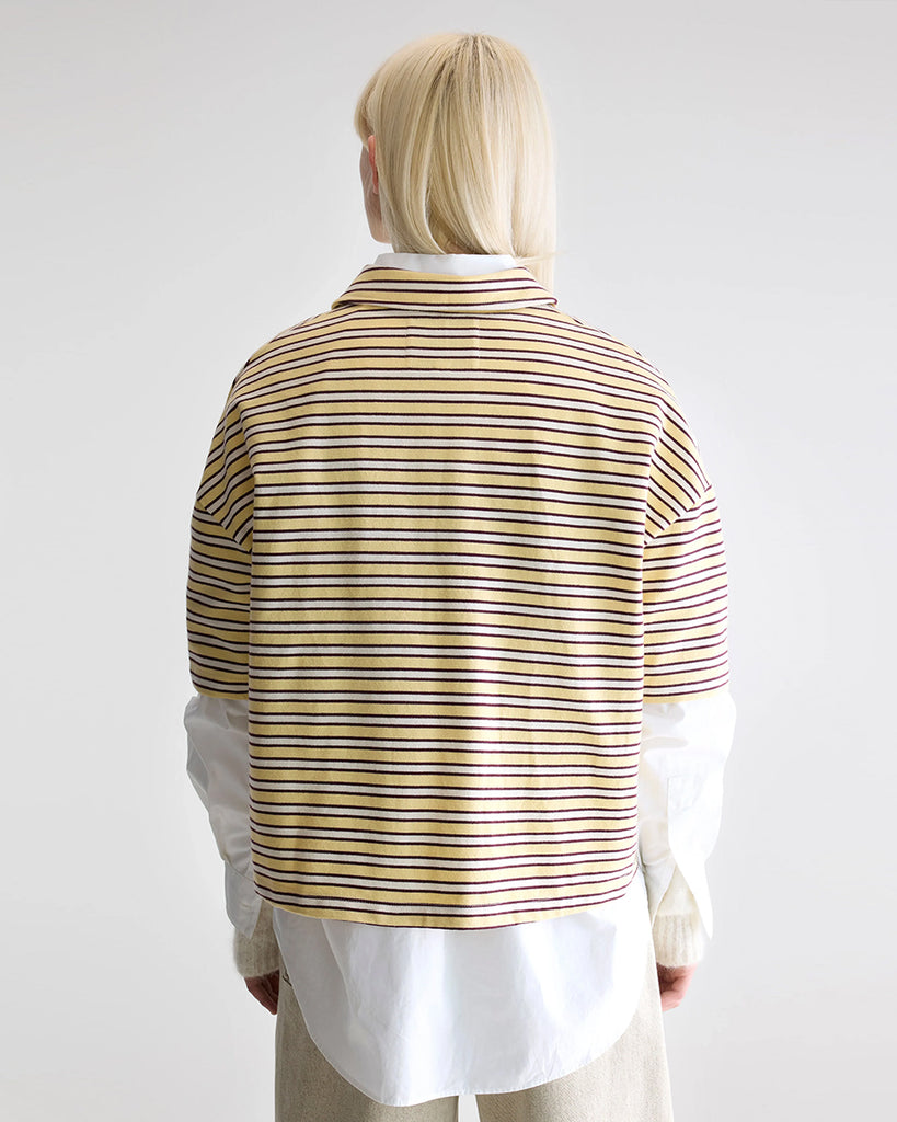 Luźna, pudełkowa koszulka polo Foolo Bellerose w paski. Posiada kołnierzyk, opadające ramiona i krótki, szeroki rękaw o długości do łokci. Pod szyją zapinana na guziki.