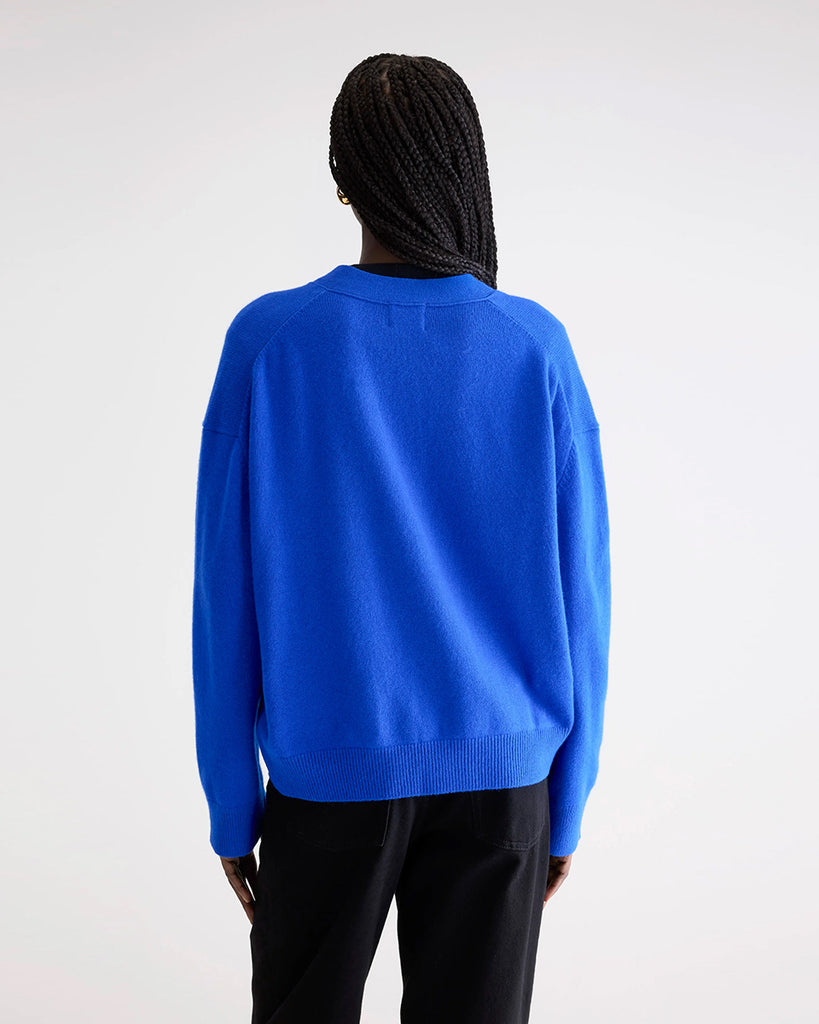 Oversizowy kardigan Gekkin Bellerose z opadającymi ramionami i luźnymi, długimi rękawami. Posiada dekolt w serek. Zapinany na guziki. Wykończony ściągaczami. Wykonany z miękkiej, naturalnej dzianiny z wełny i bawełny