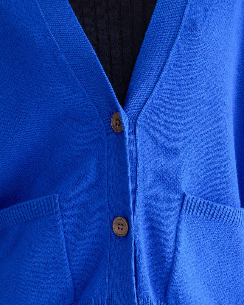 Oversizowy kardigan Gekkin Bellerose z opadającymi ramionami i luźnymi, długimi rękawami. Posiada dekolt w serek. Zapinany na guziki. Wykończony ściągaczami. Wykonany z miękkiej, naturalnej dzianiny z wełny i bawełny