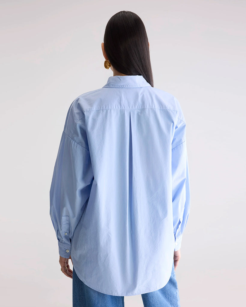 Klasyczna, oversizowa koszula w męskim stylu Giorgia Bellerose z kołnierzykiem, opadającymi ramionami i luźnymi rękawami zakończonymi mankietami. Zapinana na guziki. Posiada przednią kieszonkę na wysokości lewej piersi. Na plecach koszula ma zakładkę.