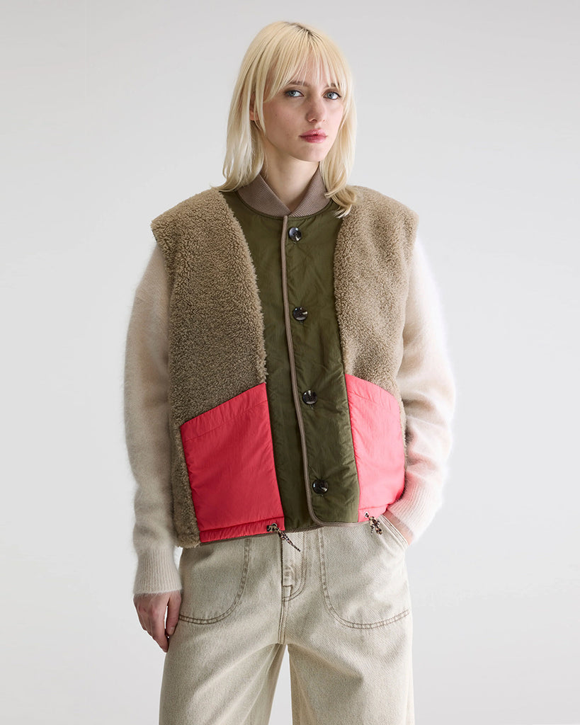 Ciepła, dwustronna kamizelka o pudełkowym fasonie Hamilton Bellerose. Z jednej strony wykonana z pikowanej, śliskiej tkaniny z drugiej ze sztucznego futra. Dekorowana kolorowymi detalami. Zapinana na guziki.