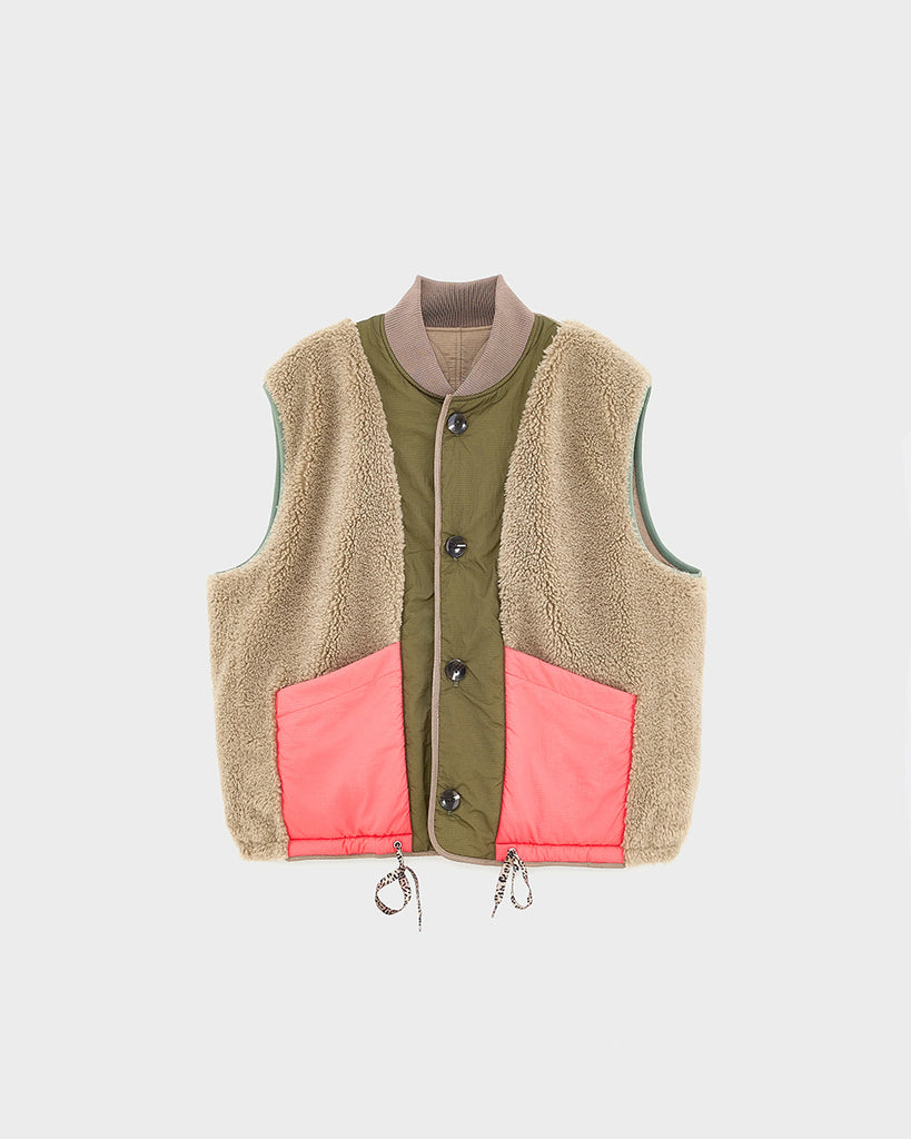 Ciepła, dwustronna kamizelka o pudełkowym fasonie Hamilton Bellerose. Z jednej strony wykonana z pikowanej, śliskiej tkaniny z drugiej ze sztucznego futra. Dekorowana kolorowymi detalami. Zapinana na guziki.