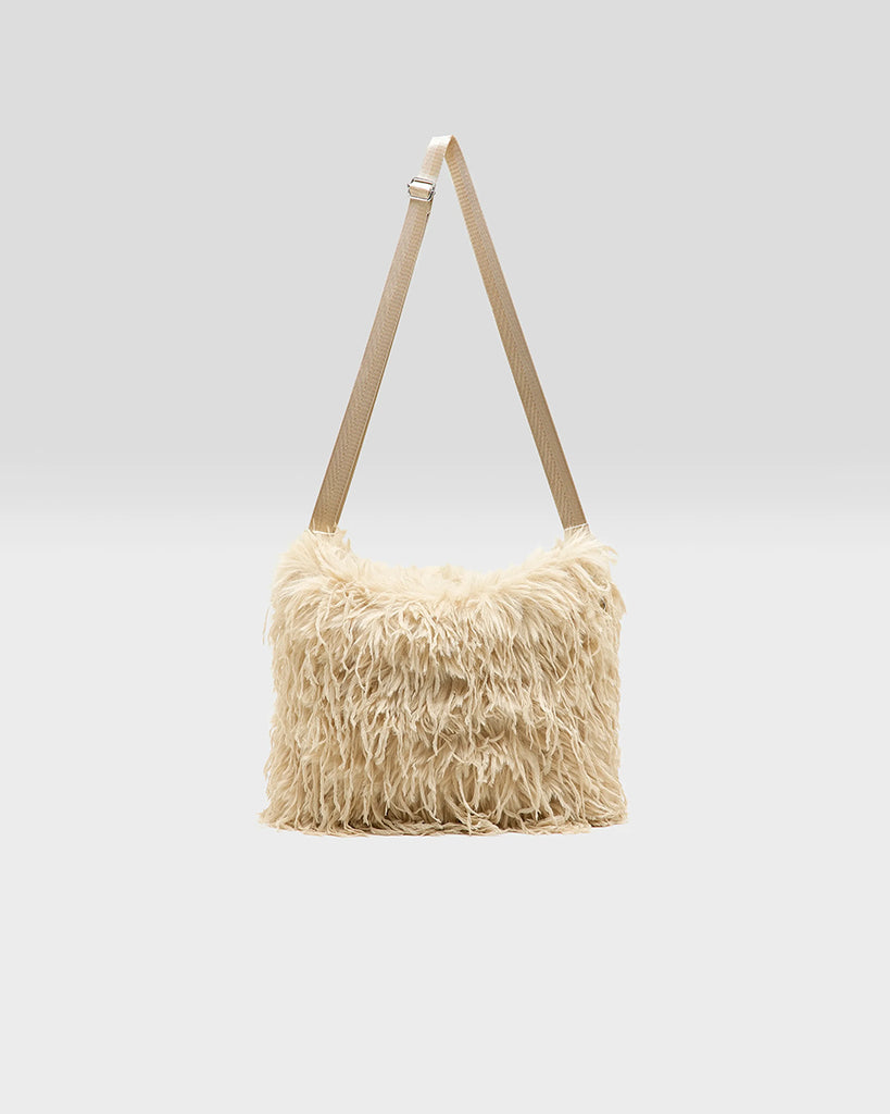 Średniej wielkości, dwustronna torba Hela Bellerose z dwoma paskami - szerokim, długim, odpinanym&nbsp; oraz krótszą rączką ze sznurka. Z jednej strony wykonana z puchatego, sztucznego futra, natomiast z drugiej z gładkiej, technicznej tkaniny. 