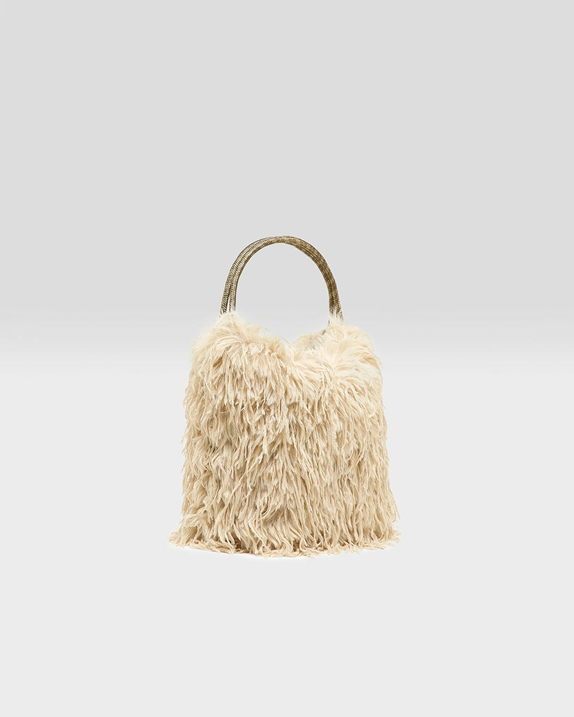 Średniej wielkości, dwustronna torba Hela Bellerose z dwoma paskami - szerokim, długim, odpinanym&nbsp; oraz krótszą rączką ze sznurka. Z jednej strony wykonana z puchatego, sztucznego futra, natomiast z drugiej z gładkiej, technicznej tkaniny. 