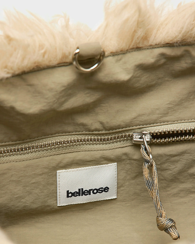 Średniej wielkości, dwustronna torba Hela Bellerose z dwoma paskami - szerokim, długim, odpinanym&nbsp; oraz krótszą rączką ze sznurka. Z jednej strony wykonana z puchatego, sztucznego futra, natomiast z drugiej z gładkiej, technicznej tkaniny. 