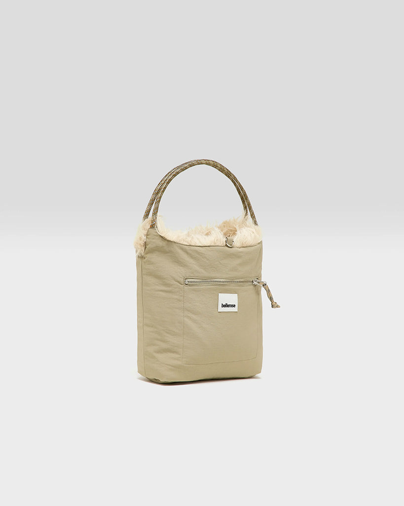 Średniej wielkości, dwustronna torba Hela Bellerose z dwoma paskami - szerokim, długim, odpinanym&nbsp; oraz krótszą rączką ze sznurka. Z jednej strony wykonana z puchatego, sztucznego futra, natomiast z drugiej z gładkiej, technicznej tkaniny. 