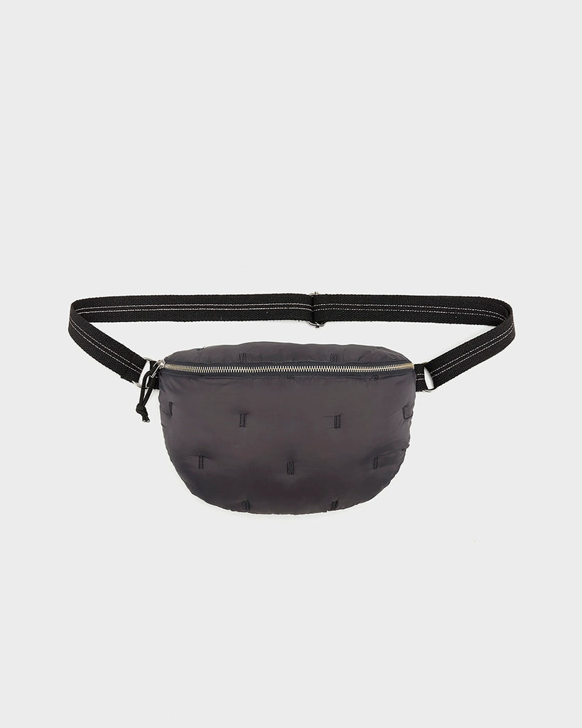 Pikowana, niewielka torebka-nerka Hosie Bellerose z miękkiej, "puchowej" tkaniny. Zapinana na zamek błyskawiczny. Wewnątrz obszyta kontrastową podszewką. Torebka ma szeroki, pleciony pasek o regulowanej długości do wygodnego przewieszenia przez ramię.