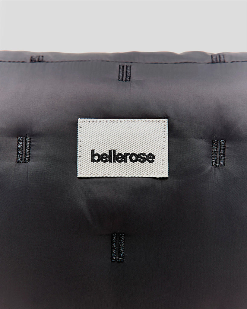 Pikowana, niewielka torebka-nerka Hosie Bellerose z miękkiej, "puchowej" tkaniny. Zapinana na zamek błyskawiczny. Wewnątrz obszyta kontrastową podszewką. Torebka ma szeroki, pleciony pasek o regulowanej długości do wygodnego przewieszenia przez ramię.