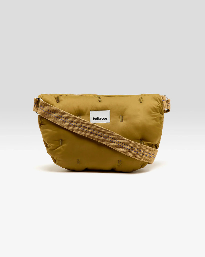 Pikowana, niewielka torebka-nerka Hosie Bellerose z miękkiej, "puchowej" tkaniny. Zapinana na zamek błyskawiczny. Wewnątrz obszyta kontrastową podszewką. Torebka ma szeroki, pleciony pasek o regulowanej długości do wygodnego przewieszenia przez ramię.