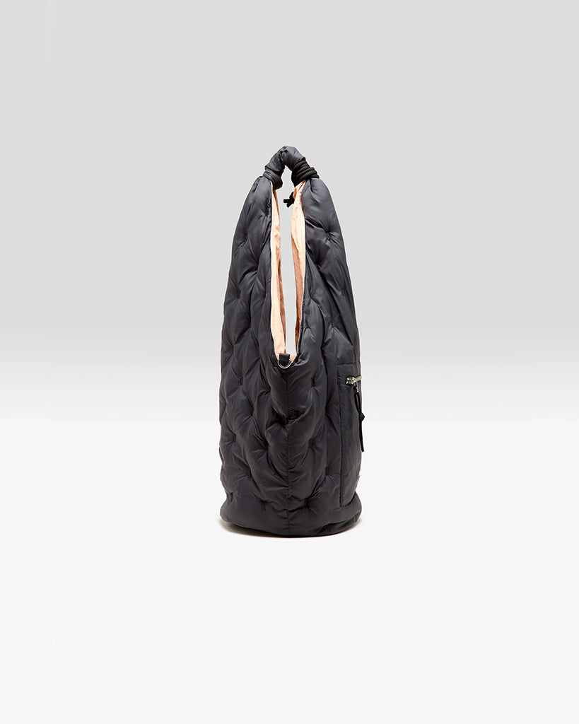 Duża, pikowana, sportowa torba Hozim Bellerose wykonana z miękkiej, tkaniny z "puchowym wypełnieniem". Wewnątrz posiada niewielką kieszonkę na najważniejsze drobiazgi i jest obszyta tkaniną w kontrastowym kolorze. Torba od góry zapinana jest za pomocą paska i karabińczyka i posiada zewnętrzną kieszeń zapinaną na zamek błyskawiczny, na której znajduje się niewielkie logo marki.