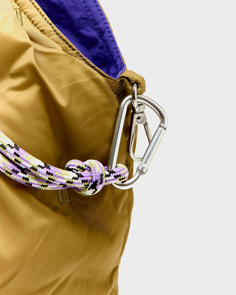 Duża, pikowana, sportowa torba Hozim Bellerose wykonana z miękkiej, tkaniny z "puchowym wypełnieniem". Wewnątrz posiada niewielką kieszonkę na najważniejsze drobiazgi i jest obszyta tkaniną w kontrastowym kolorze. Torba od góry zapinana jest za pomocą paska i karabińczyka i posiada zewnętrzną kieszeń zapinaną na zamek błyskawiczny, na której znajduje się niewielkie logo marki.