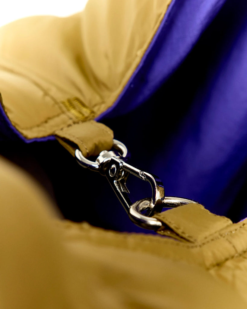 Duża, pikowana, sportowa torba Hozim Bellerose wykonana z miękkiej, tkaniny z "puchowym wypełnieniem". Wewnątrz posiada niewielką kieszonkę na najważniejsze drobiazgi i jest obszyta tkaniną w kontrastowym kolorze. Torba od góry zapinana jest za pomocą paska i karabińczyka i posiada zewnętrzną kieszeń zapinaną na zamek błyskawiczny, na której znajduje się niewielkie logo marki.