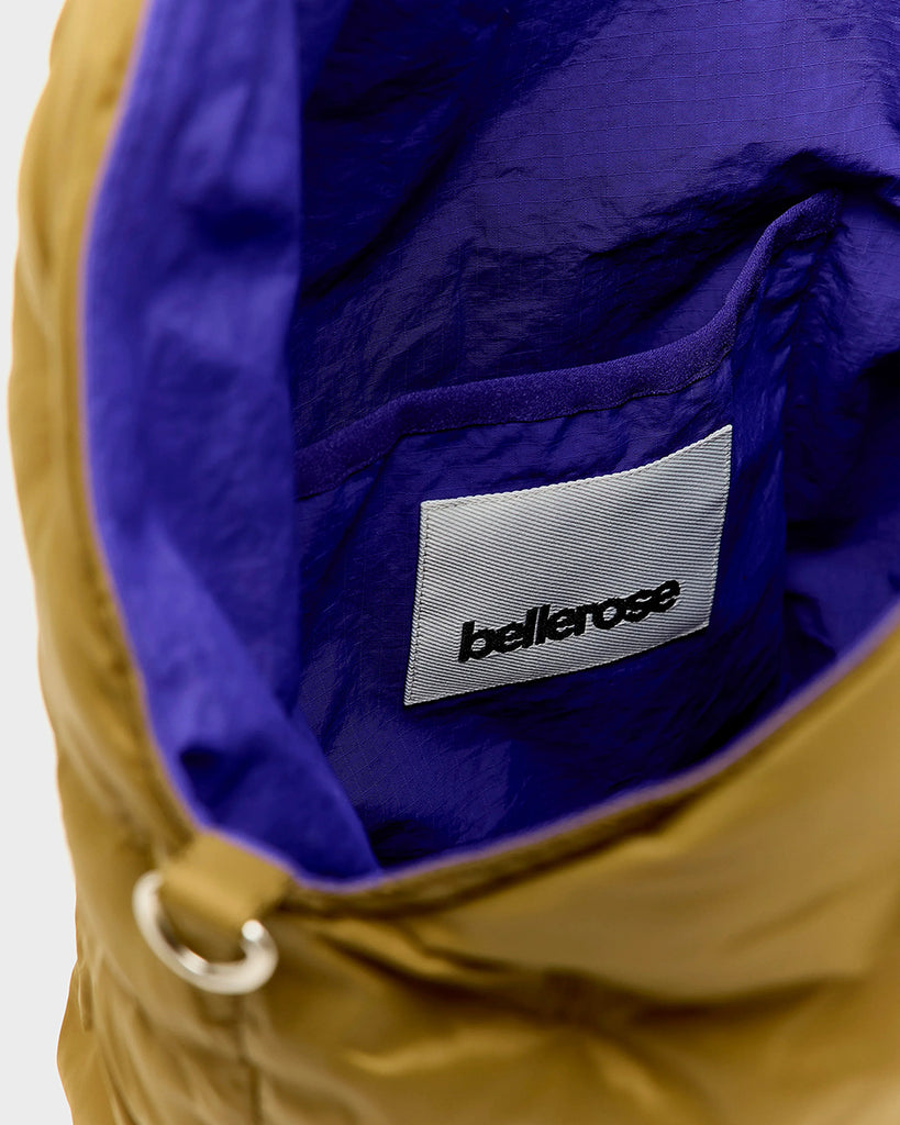 Duża, pikowana, sportowa torba Hozim Bellerose wykonana z miękkiej, tkaniny z "puchowym wypełnieniem". Wewnątrz posiada niewielką kieszonkę na najważniejsze drobiazgi i jest obszyta tkaniną w kontrastowym kolorze. Torba od góry zapinana jest za pomocą paska i karabińczyka i posiada zewnętrzną kieszeń zapinaną na zamek błyskawiczny, na której znajduje się niewielkie logo marki.