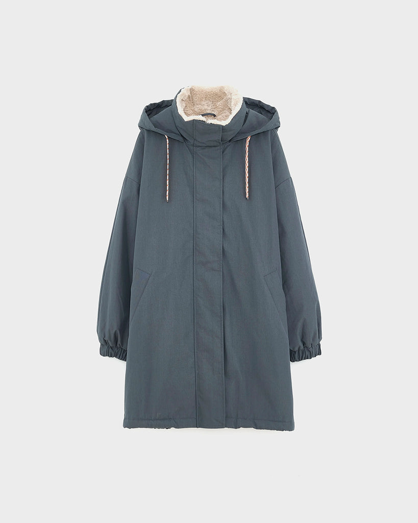 Długa, oversizowa parka Jade Bellerose z kapturem i ciepłą podpinką ze sztucznego futra w kontrastowym kolorze. Kurtka ma opadające ramiona i szerokie rękawy zakończone elastycznym ściągaczem. Posiada dwie, boczne kieszenie. 