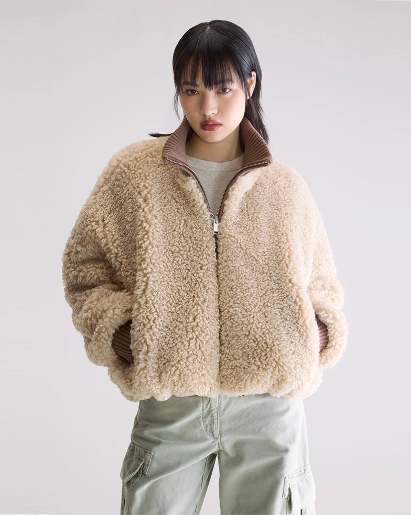 Krótka, ciepła kurtka Jallis Bellerose ze sztucznego, miłego w dotyku kożucha. Posiada wysoki, kontrastowy kołnierz z prążkowaną fakturą i takie same ściągacze przy końcach rękawów. Zapinana na zamek błyskawiczny. 