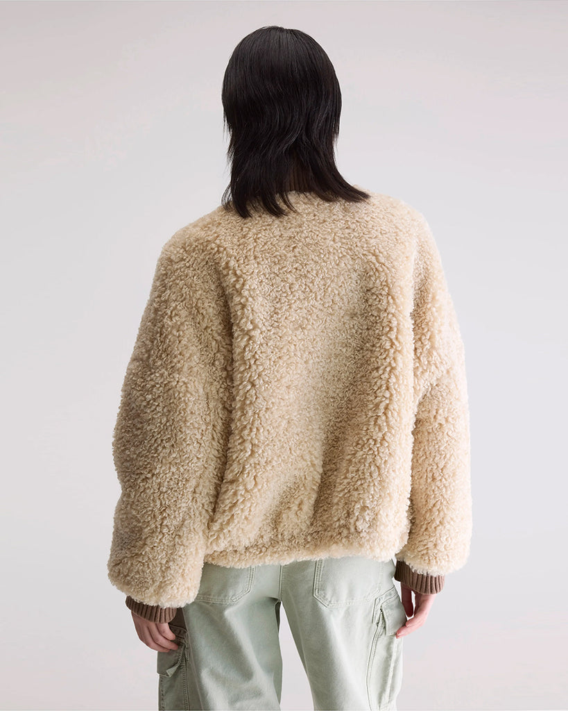 Krótka, ciepła kurtka Jallis Bellerose ze sztucznego, miłego w dotyku kożucha. Posiada wysoki, kontrastowy kołnierz z prążkowaną fakturą i takie same ściągacze przy końcach rękawów. Zapinana na zamek błyskawiczny. 