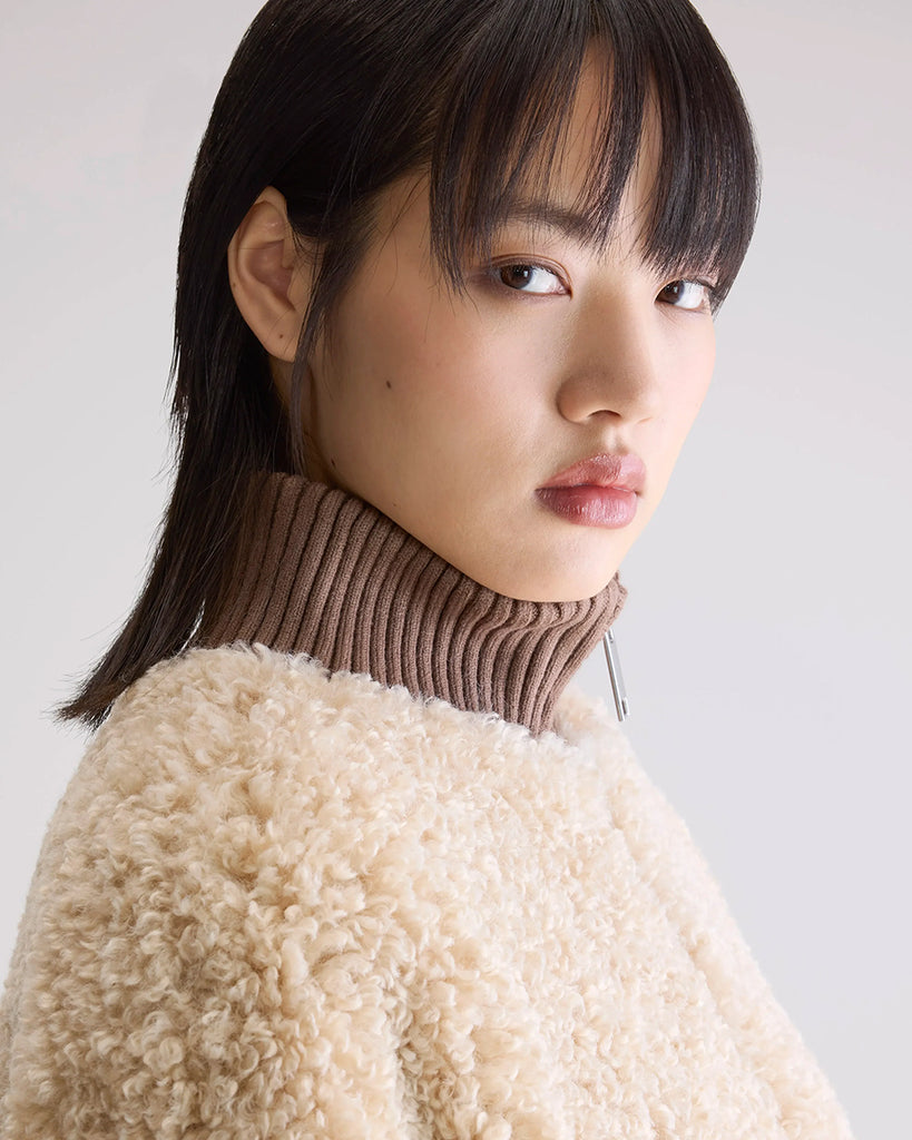 Krótka, ciepła kurtka Jallis Bellerose ze sztucznego, miłego w dotyku kożucha. Posiada wysoki, kontrastowy kołnierz z prążkowaną fakturą i takie same ściągacze przy końcach rękawów. Zapinana na zamek błyskawiczny. 