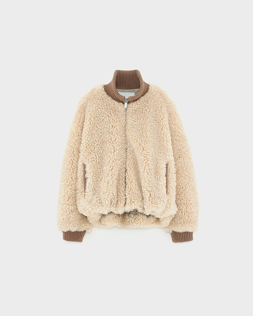 Krótka, ciepła kurtka Jallis Bellerose ze sztucznego, miłego w dotyku kożucha. Posiada wysoki, kontrastowy kołnierz z prążkowaną fakturą i takie same ściągacze przy końcach rękawów. Zapinana na zamek błyskawiczny. 